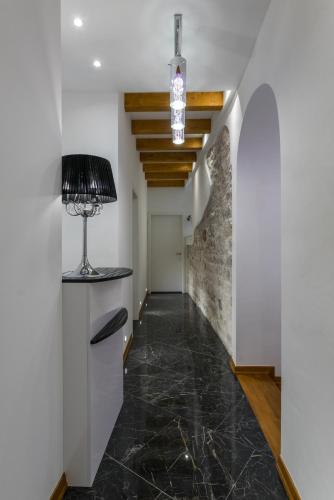 a hallway with a stone floor and a ceiling with a lamp at ID Regal Residence in Split