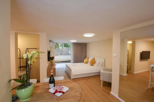 ein Wohnzimmer mit einem weißen Bett und einem Sofa in der Unterkunft Rothschild Luxury Suite Haifa in Haifa