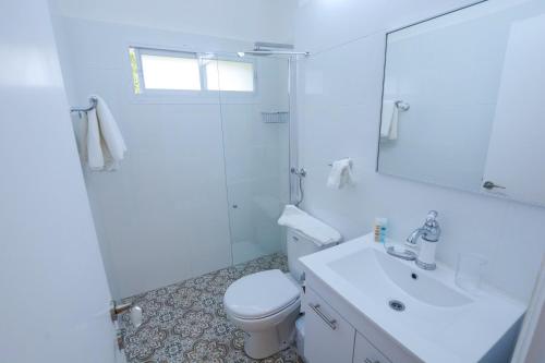 ein weißes Bad mit einem WC und einer Dusche in der Unterkunft Rothschild Luxury Suite Haifa in Haifa