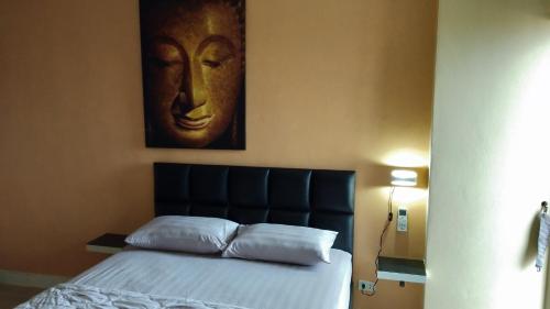 een slaapkamer met een bed met een hoofdeinde en een schilderij bij View Talay 1B by Fernando in Pattaya South