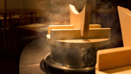 a pot on top of a stove with smoke at Laforet Ito Onsen Yunoniwa in Ito