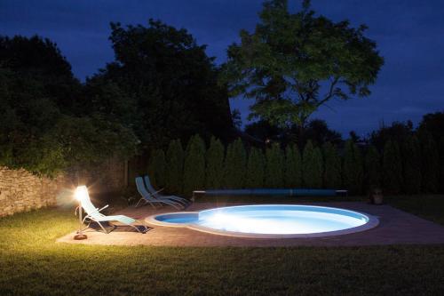 a swimming pool in a yard at night at Hétkanyar Vendégház in Nagyvázsony
