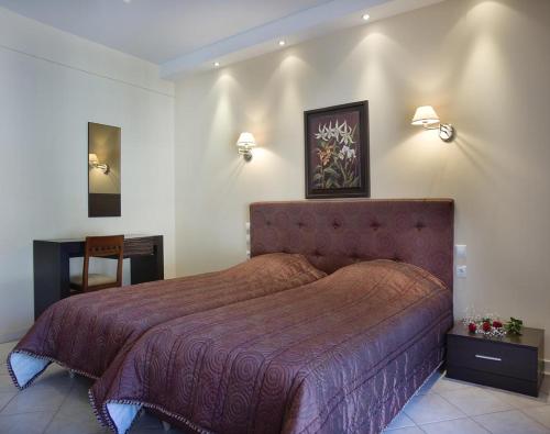 a bedroom with a large bed with a red bedspread at Plaza Hotel in Nafpaktos