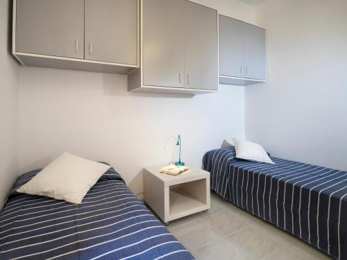 two beds sitting next to each other in a room at siciliacasevacanze - Casa Girasole in Marina di Ragusa