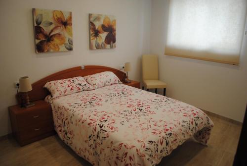 a bedroom with a bed and two paintings on the wall at Apartaments el tiet in Sant Carles de la Ràpita