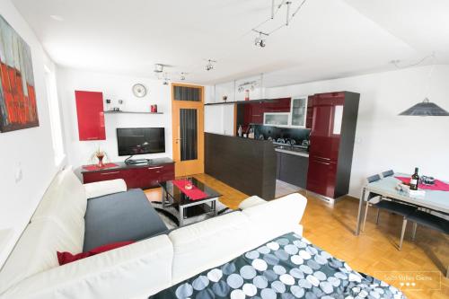 ein Wohnzimmer mit einem weißen Sofa und einer Küche in der Unterkunft Luxurious RUBY Apartment with SAUNA in Kobarid