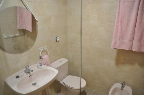 a bathroom with a sink and a toilet and a mirror at Costahispania 308 in Gran Alacant