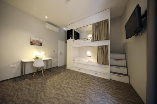 a bedroom with a bed and a desk and a television at Downtown Boutique Hostel in Zadar