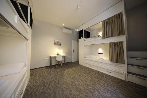 a bedroom with a bed and a desk in it at Downtown Boutique Hostel in Zadar