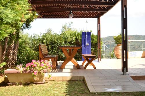 a patio with a table and two chairs and flowers at Villa Rotunda A in Kolymvari