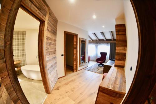 a bathroom with a large mirror and a tub at Hotel Alpenrose Wellness in Vattaro