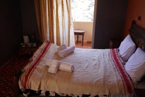 a bed with towels on it with a window at Berber Family Lodge in Imlil