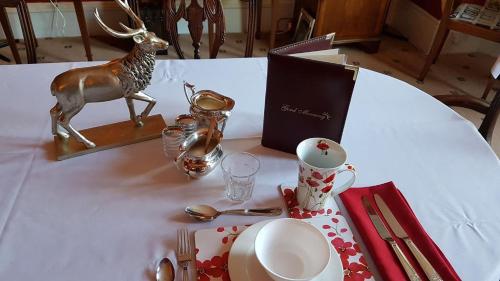 a table with a plate and a statue of a deer on it at Holywell House in Loughborough
