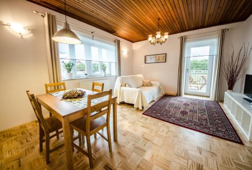 a living room with a table and chairs and a couch at Apartments Vila Marjetica in Bled
