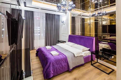 リヴィウにあるRoyal Luxury apartment on Tsehova 9のベッドルーム(紫色のベッド1台、テレビ付)