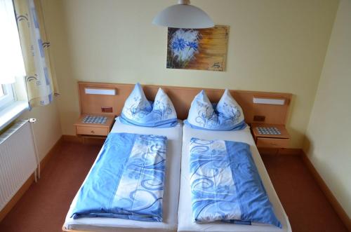 1 dormitorio con 2 camas y almohadas azules y blancas en Gästehaus Familie Grudl en Bärnkopf