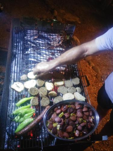 a person is cooking food on a grill at Anatoli Hotel in Agia Marina Aegina