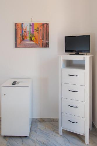 a white dresser with a television on top of it at Hotel San Giovanni in Polignano a Mare