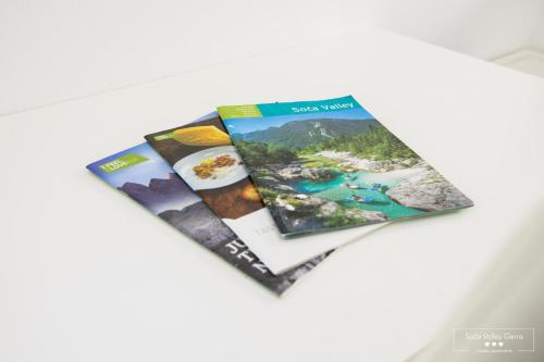 two magazines sitting on top of a table at Emerald Soca Apartment in Tolmin