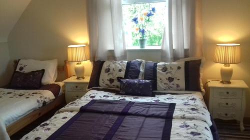 1 dormitorio con 1 cama, 2 lámparas y ventana en Atlantic Haven Bed & Breakfast, en Grange