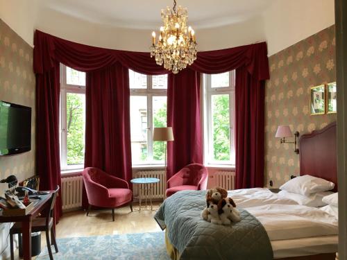 a bedroom with a dog sitting on a bed at Hotel Kung Carl, WorldHotels Crafted in Stockholm