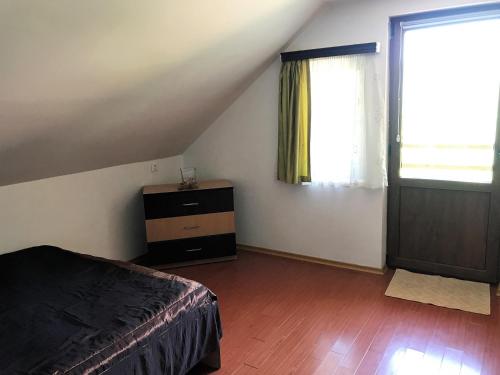 a bedroom with a bed and a dresser and a window at Lacul Racilor in Olimp