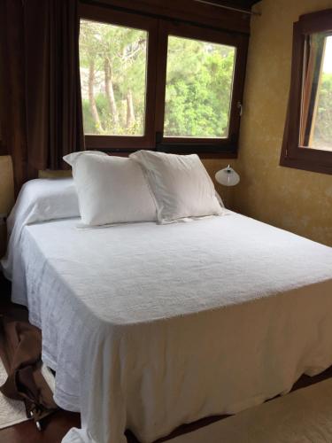 カルロフォルテにあるVilla Con Piscina a Carloforteのベッドルーム1室(白いシーツ付きのベッド1台、窓2つ付)