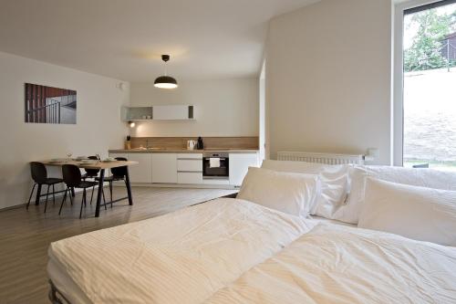a bedroom with a bed and a table and a kitchen at Lakepark Residence in Staré Splavy