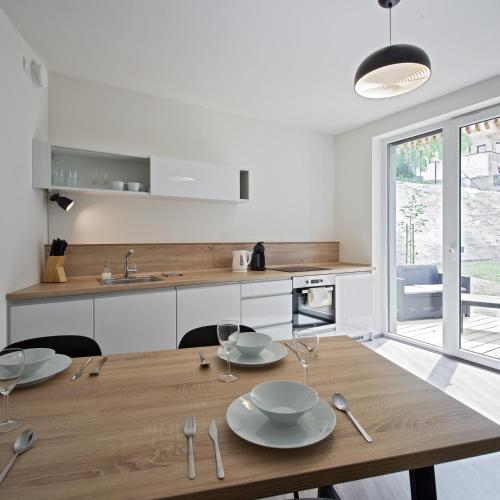 a kitchen and dining room with a wooden table at Lakepark Residence in Staré Splavy