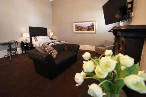 a bedroom with a bed and a chair and a couch at Ballarat Premier Apartments in Ballarat