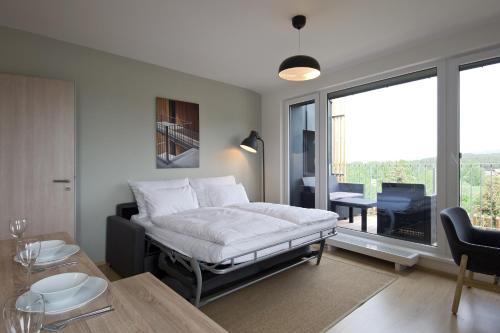 a bedroom with a bed and a table and a balcony at Lakepark Residence in Staré Splavy