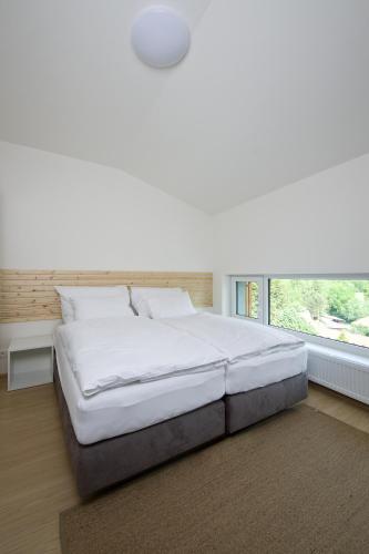 a large bed in a bedroom with a large window at Lakepark Residence in Staré Splavy