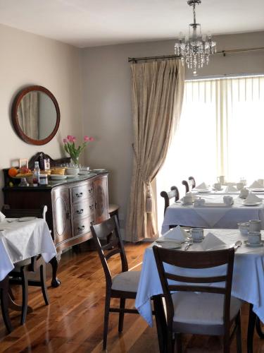una sala da pranzo con tavoli, sedie e specchio di Sli Na Mara a Galway