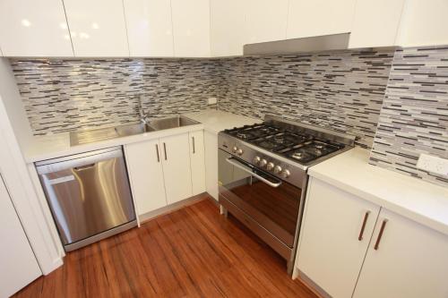 a kitchen with a stove and a sink at Ballarat Premier Apartments in Ballarat