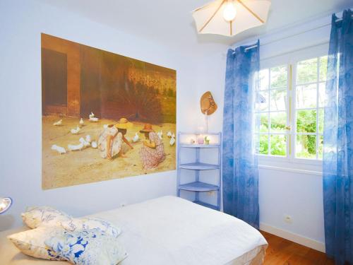 アングレットにあるVilla in France near Beach & Private Poolの壁に絵画が描かれたベッドルーム、ベッド1台が備わります。