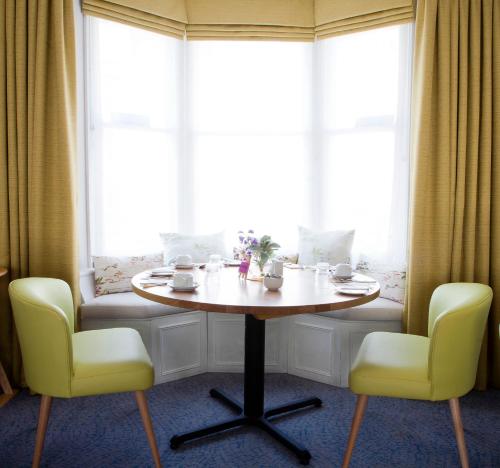 a table and chairs in a room with windows at Sea Spray Hotel in Brighton & Hove