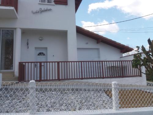 una casa bianca con una recinzione di fronte di villa rue gainekoa a Cambo-les-Bains