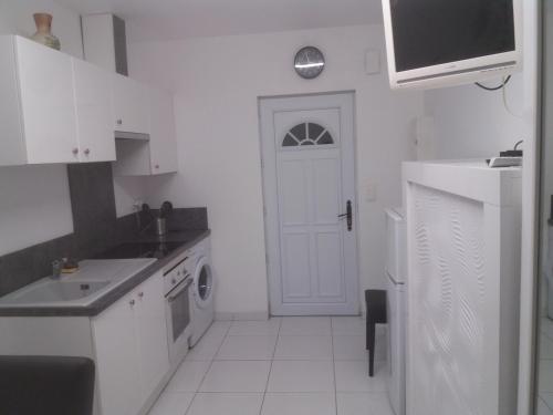 a kitchen with white cabinets and a white door at villa rue gainekoa in Cambo-les-Bains