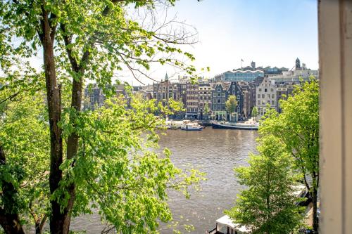 a view of a river with boats in a city at Zwanestein Canal House in Amsterdam