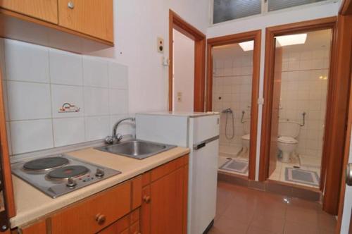 een keuken met een wastafel en een witte koelkast bij Hotel Elvetia in Panayia