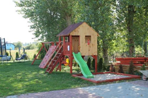 ein Spielset mit Rutsche und Spielplatz in der Unterkunft Pensjonat nad Stawem in Sarbinowo