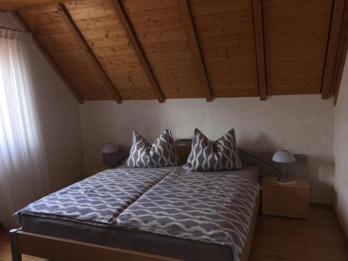 ein Schlafzimmer mit einem Bett mit Kissen darauf in der Unterkunft Haus am Südfrüchtegarten in Rhodt unter Rietburg