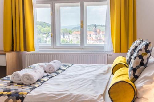 two babies wrapped in towels on a bed with a window at Boutique hotel Villa Beatika in Český Krumlov