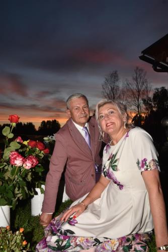 a man and a woman sitting next to flowers at Holiday Home Ermine in Sigulda