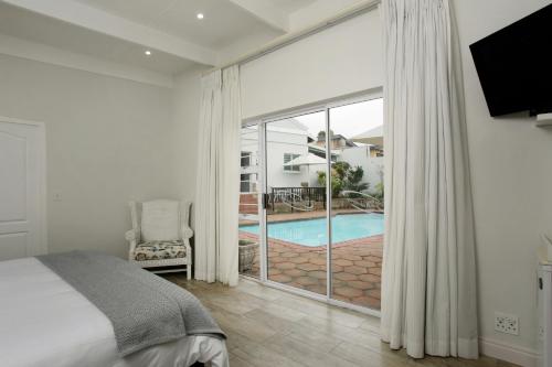 a bedroom with a bed and a view of a pool at Ocean Hideaway Bed and Breakfast in Amanzimtoti