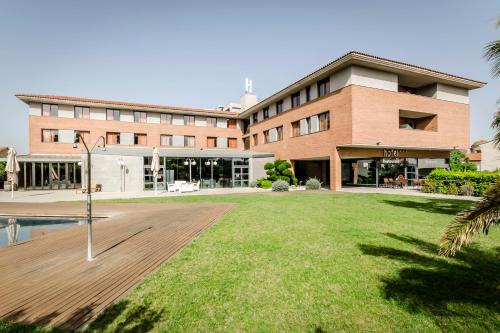 a large building with a lawn in front of it at Crisol La Selva in La Selva del Camp