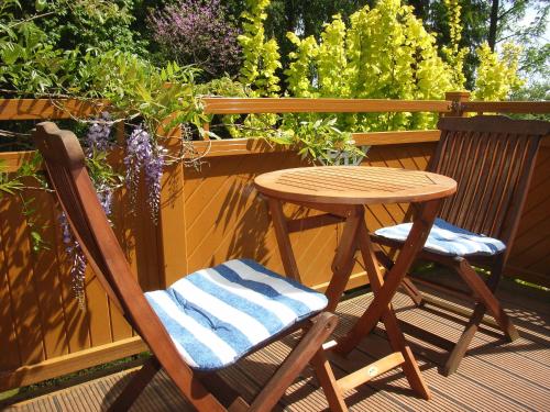 a wooden table and chair sitting on a deck at Ostsee Hotel-Pension An der Lindenallee in Bad Doberan