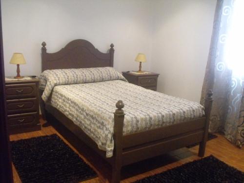 a bedroom with a bed and two night stands with lamps at Alto da Bela Vista in Terra Alta