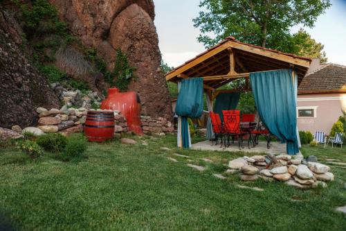 a gazebo with a table and chairs in a yard at Villa Kada in Belogradchik