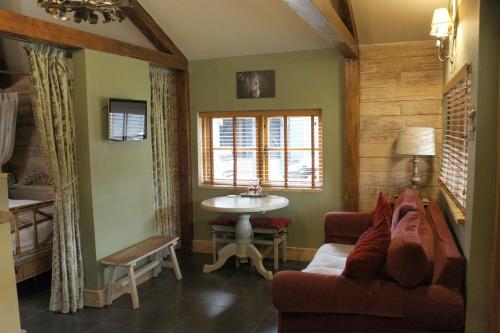 ein Wohnzimmer mit einem Sofa und einem Waschbecken in der Unterkunft The Devils Cradle in Farnham